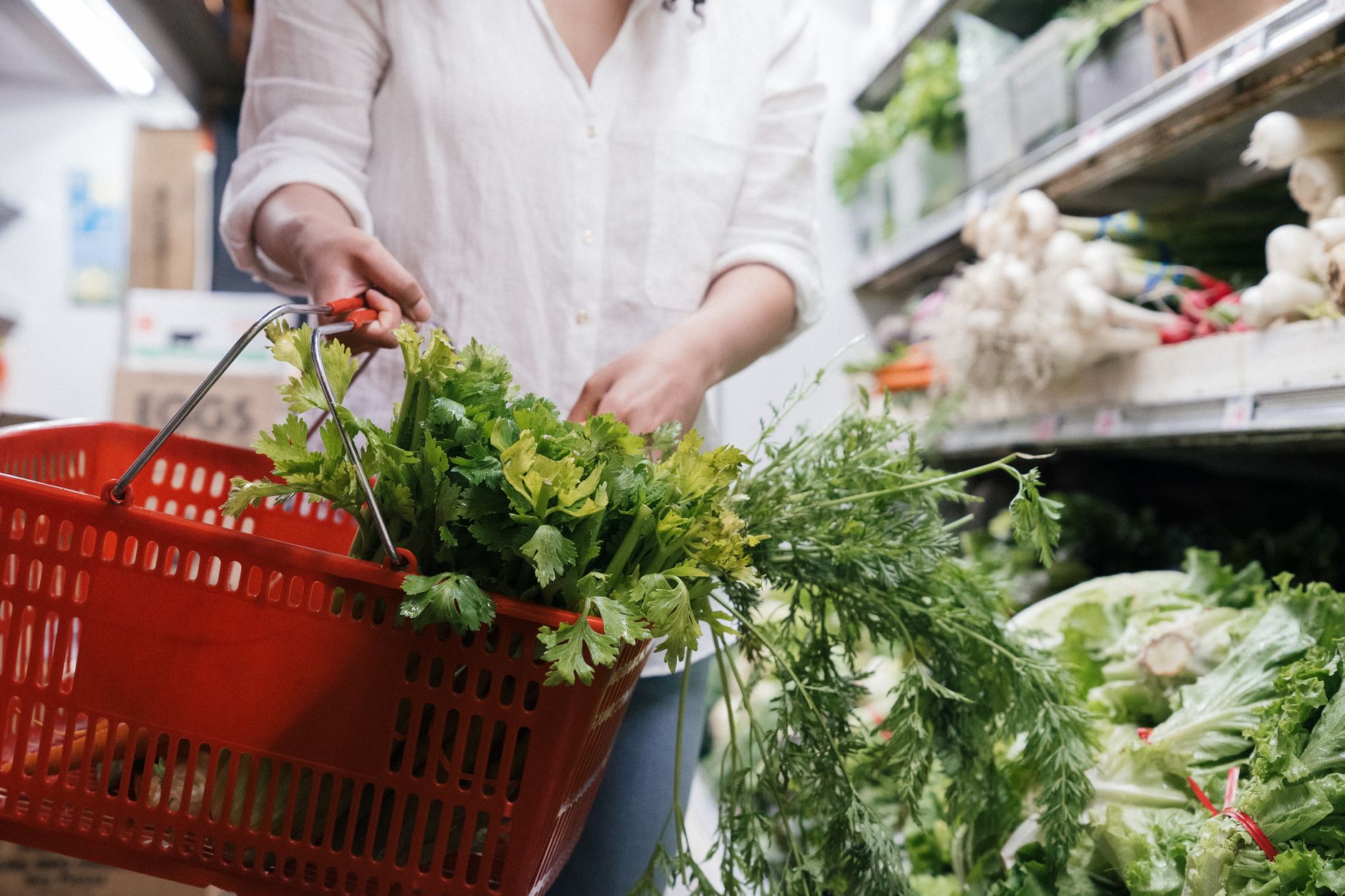 Grocery basket filled with fresh greens and produce